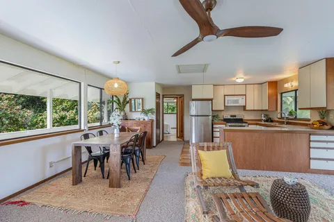 a kitchen with stainless steel appliances granite countertop a refrigerator a sink dishwasher a dining table and chairs with wooden floor