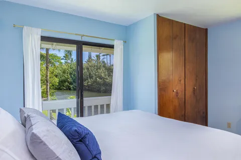 a bedroom with a bed and a large window