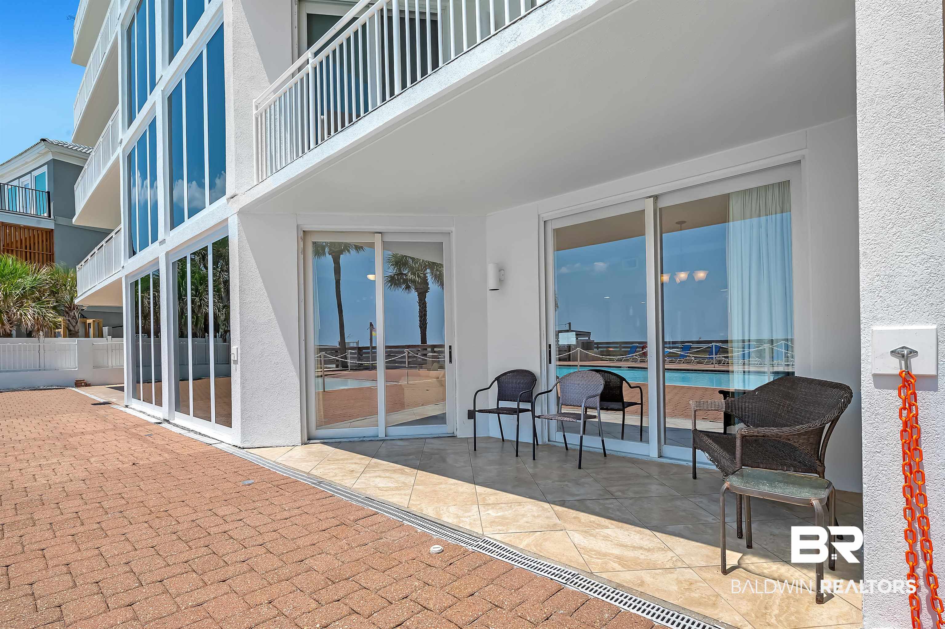 16287 Perdido Key Drive, Unit 105 Pensacola, FL 32507 - Photo 41 of 66 Expansive brick paver patio with a tiled outdoor seating area