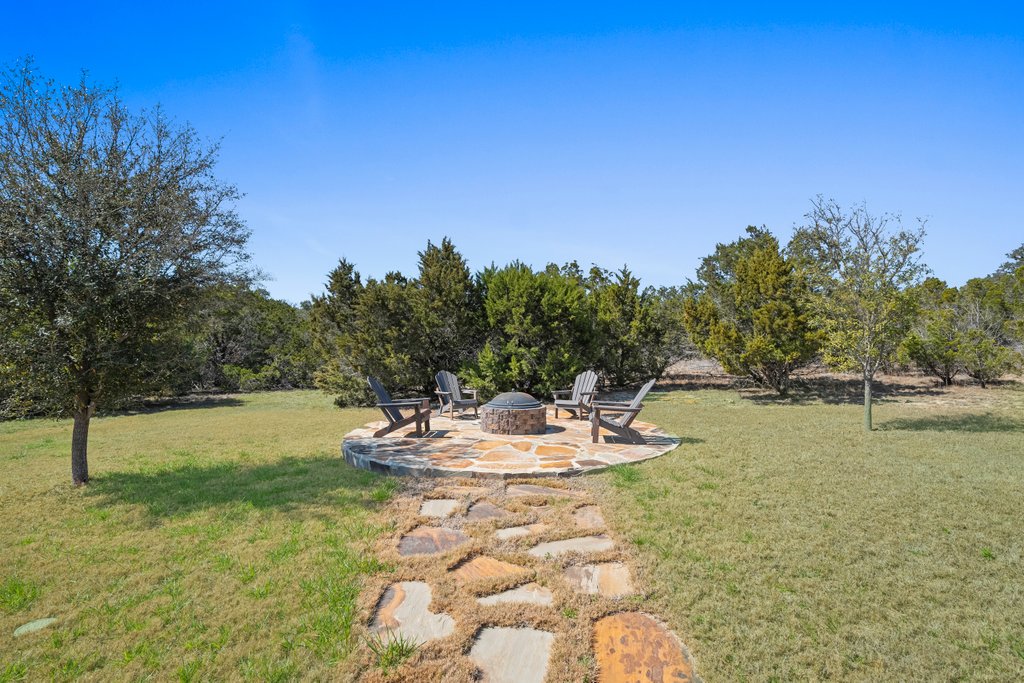 541 Stars And Stripes Fischer, TX 78623 - Photo 23 of 26 Stone walkway from the covered patio to the fire pit.