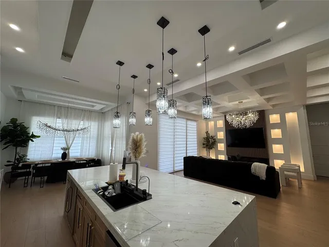 a kitchen with a stove a refrigerator and a dining table with wooden floor