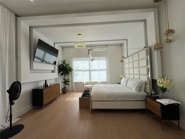a bedroom with a bed mirror and window