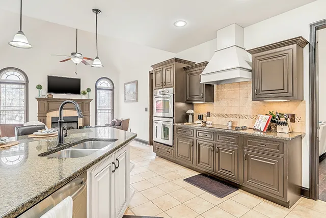 a kitchen with a granite countertop sink a large mirror and a window