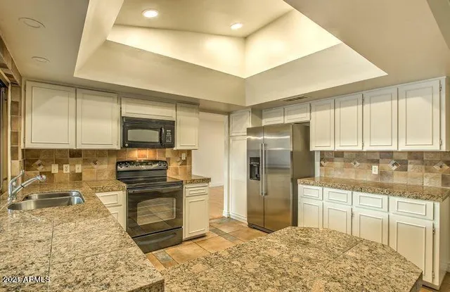 a kitchen with stainless steel appliances granite countertop a stove a sink and a refrigerator