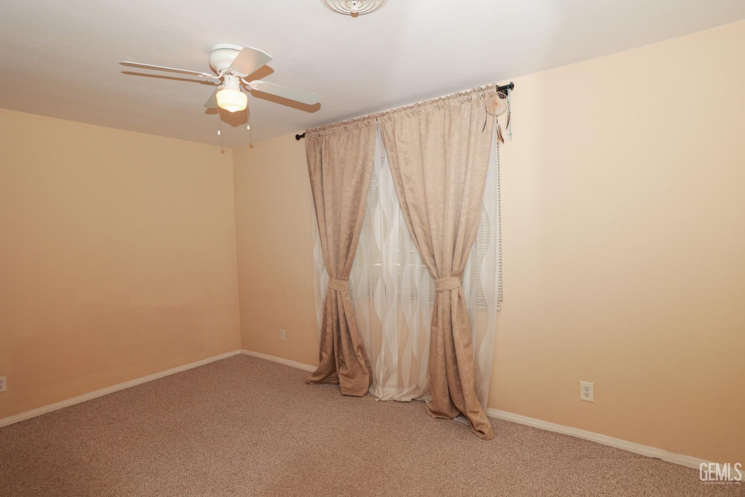 Undisclosed Address Lake Isabella, CA 93240 - Photo 26 of 46 an empty room with a chandelier fan and a window