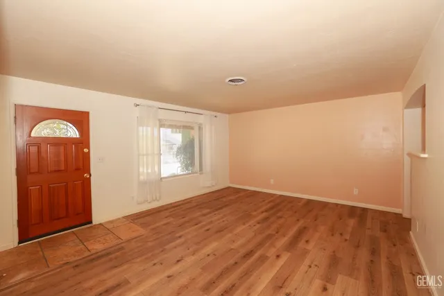 a view of empty room with wooden floor and cabinet