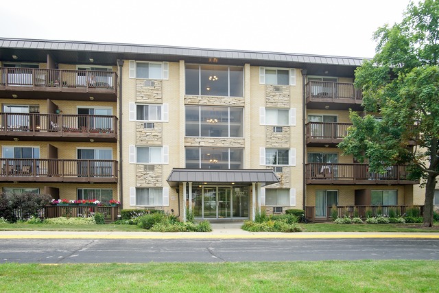 2222 South Goebbert Road, Unit 361 Arlington Heights, IL 60005 - Photo 1 of 10 a front view of a residential apartment building with a yard