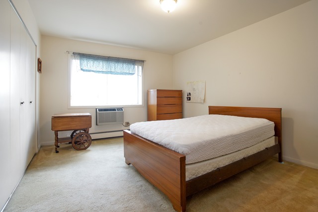 2222 South Goebbert Road, Unit 361 Arlington Heights, IL 60005 - Photo 5 of 10 a bed sitting in a bedroom next to a window