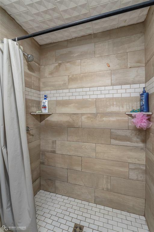 143 New Bethel Booker Road Benton, LA 71006 - Photo 12 of 26 Walk-in shower featuring wood-look plank tile walls with a subway tile accent, a white subway tile floor, and integrated corner shelves