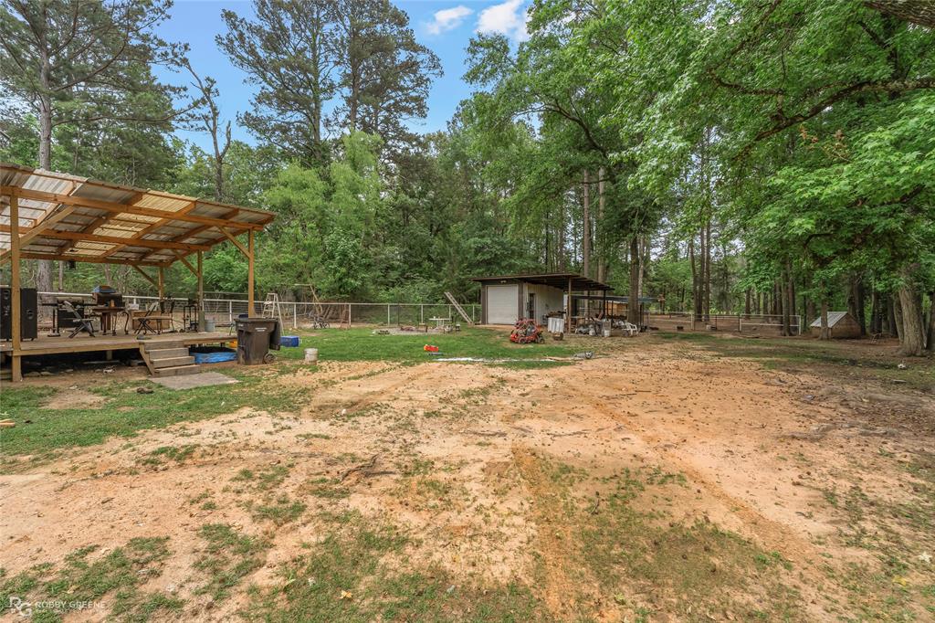 143 New Bethel Booker Road Benton, LA 71006 - Photo 19 of 26 Wood-framed covered deck with a corrugated metal roof, elevated above ground level