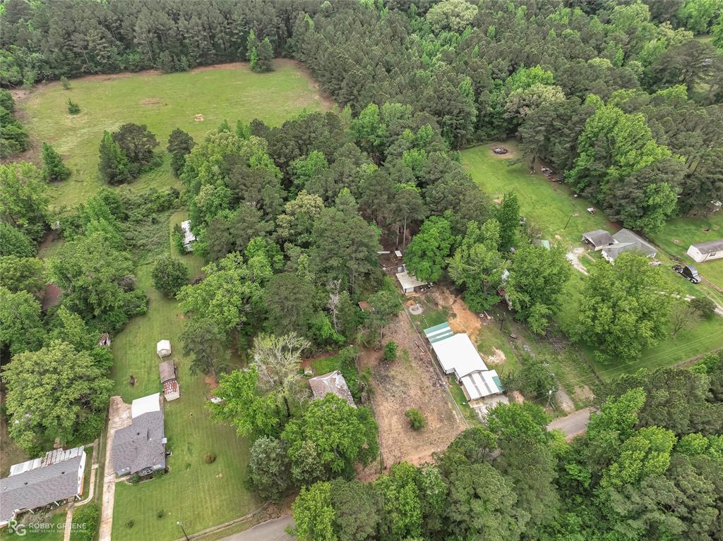 143 New Bethel Booker Road Benton, LA 71006 - Photo 21 of 26 Aerial perspective of a sprawling property featuring wooded areas and open clearings