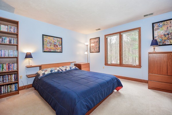 583 Sugar Road Bolton, MA 01740 - Photo 21 of 30 a bedroom with a bed and a book shelf