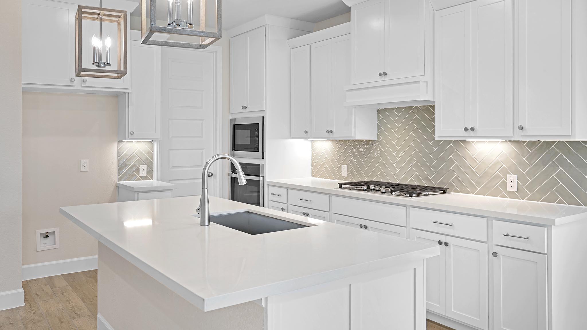 338 Prickly Poppy Loop Kyle, TX 78640 - Photo 8 of 40 Kitchen with hanging light fixtures, a kitchen island with sink, tasteful backsplash, white cabinetry, and stainless steel appliances