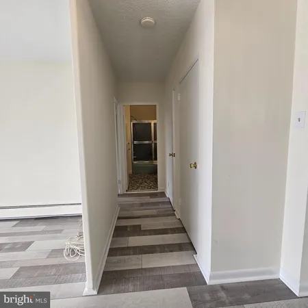 a view of a hallway with wooden floor and entryway