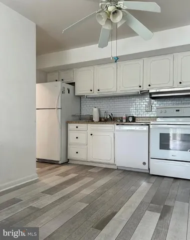a kitchen with stainless steel appliances white cabinets and a refrigerator