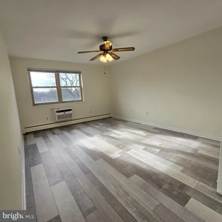 an empty room with windows and fan