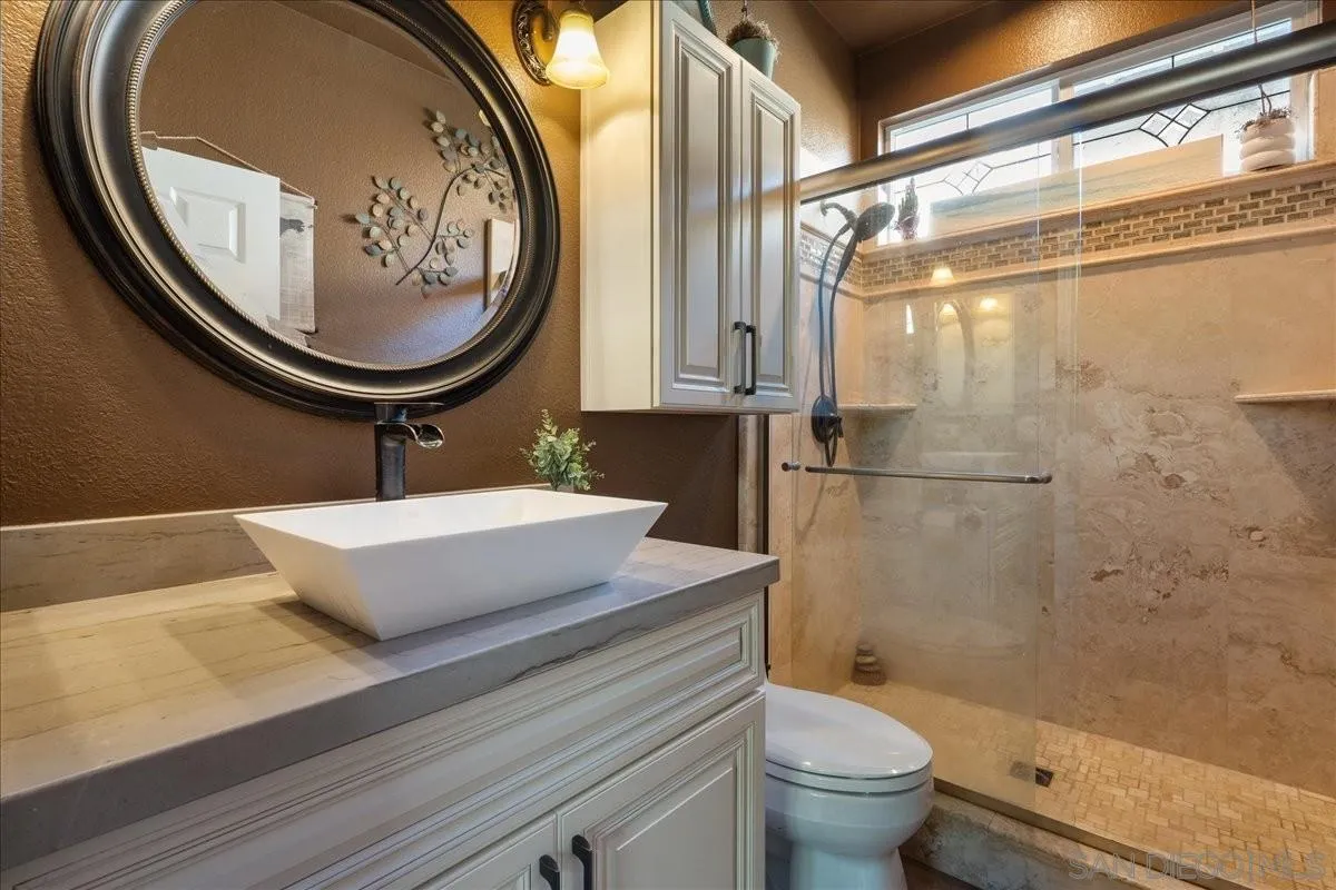 5471 Foxtail Loop Carlsbad, CA 92010 - Photo 10 of 22 a bathroom with a toilet a sink and a mirror