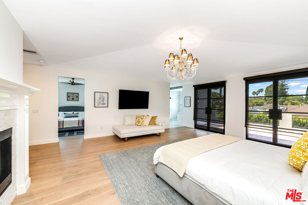 4843 Ledge Avenue Toluca Lake, CA 91601 - Photo 18 of 31 a spacious bedroom with a bed and a flat screen tv