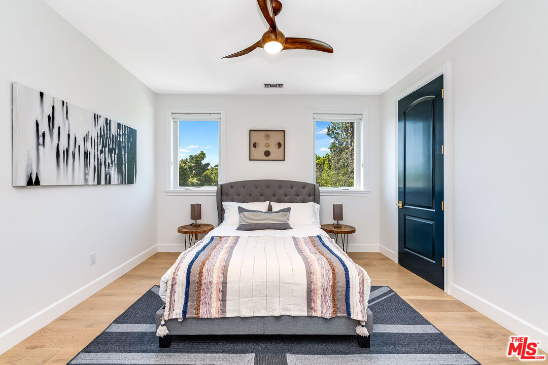 4843 Ledge Avenue Toluca Lake, CA 91601 - Photo 22 of 31 a bedroom with a bed and a chandelier