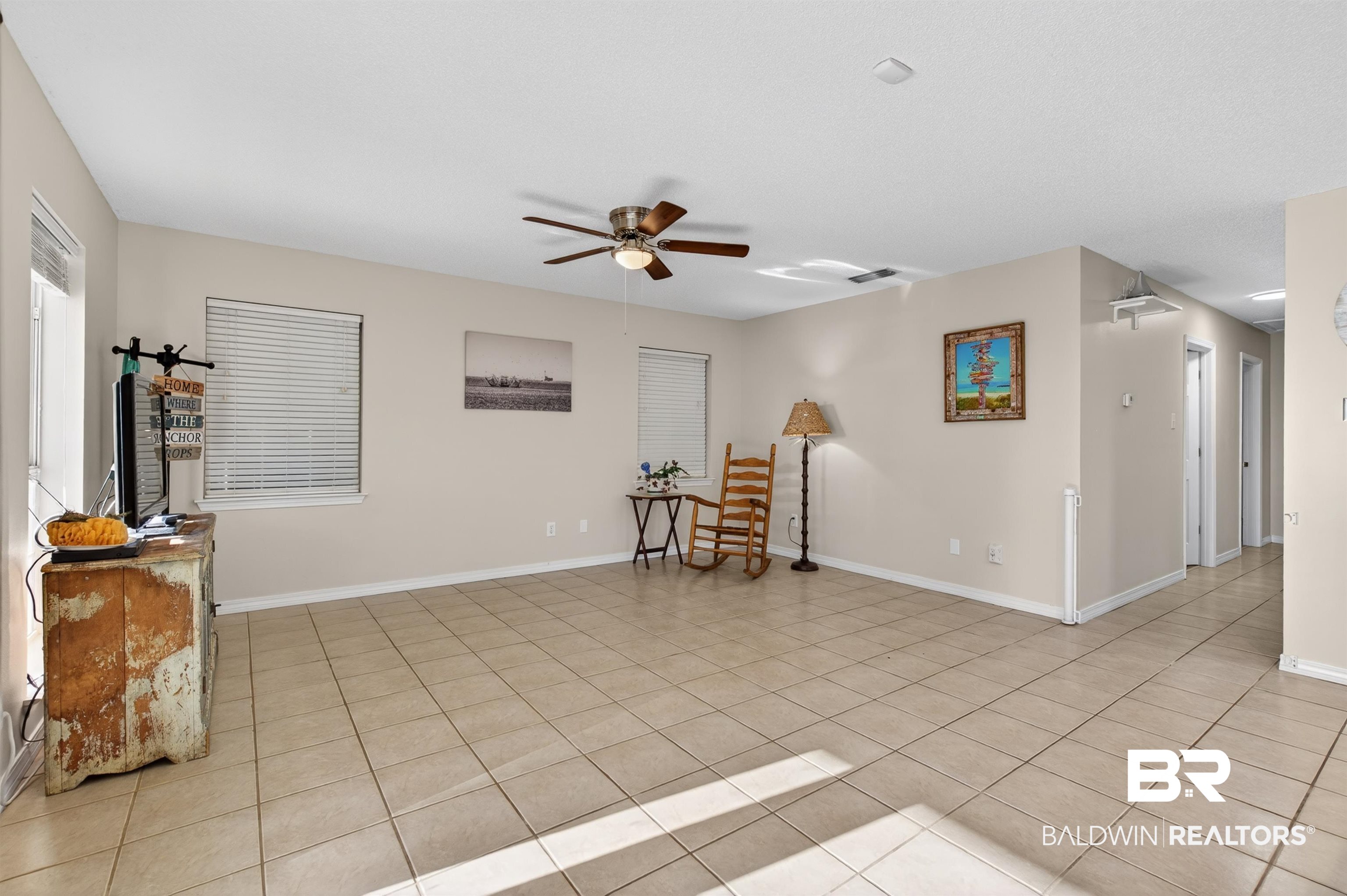 9624 North Bay Street Foley, AL 36535 - Photo 6 of 59 Spacious living area featuring light-toned tile flooring, neutral wall paint, and multiple windows with blinds