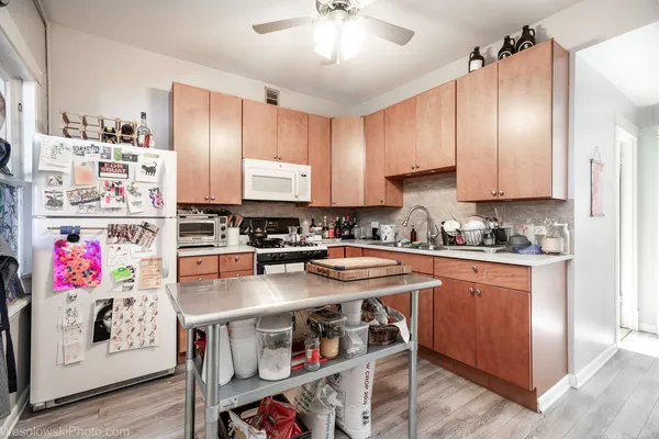 a kitchen with stainless steel appliances granite countertop a stove refrigerator and cabinets
