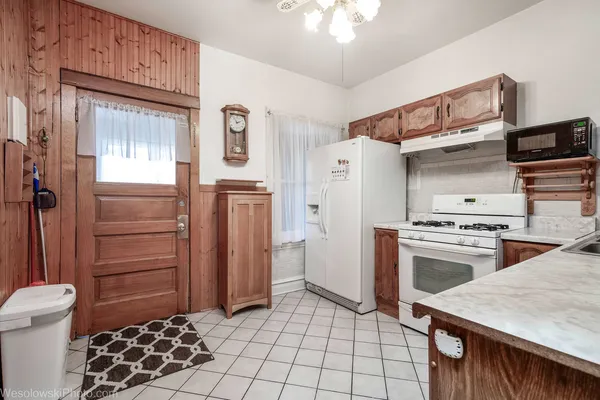 a kitchen with a stove a refrigerator and cabinets