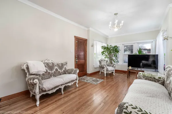 a living room with furniture a chandelier and a flat screen tv