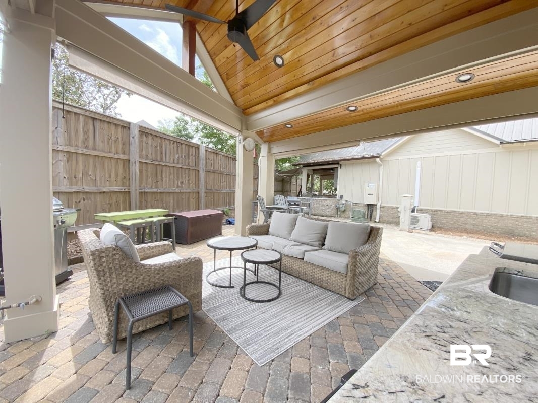 28888 Canal Road, Unit 77 Orange Beach, AL 36561 - Photo 14 of 23 Covered outdoor patio featuring a vaulted wood-finish ceiling, exposed beams, and a ceiling fan
