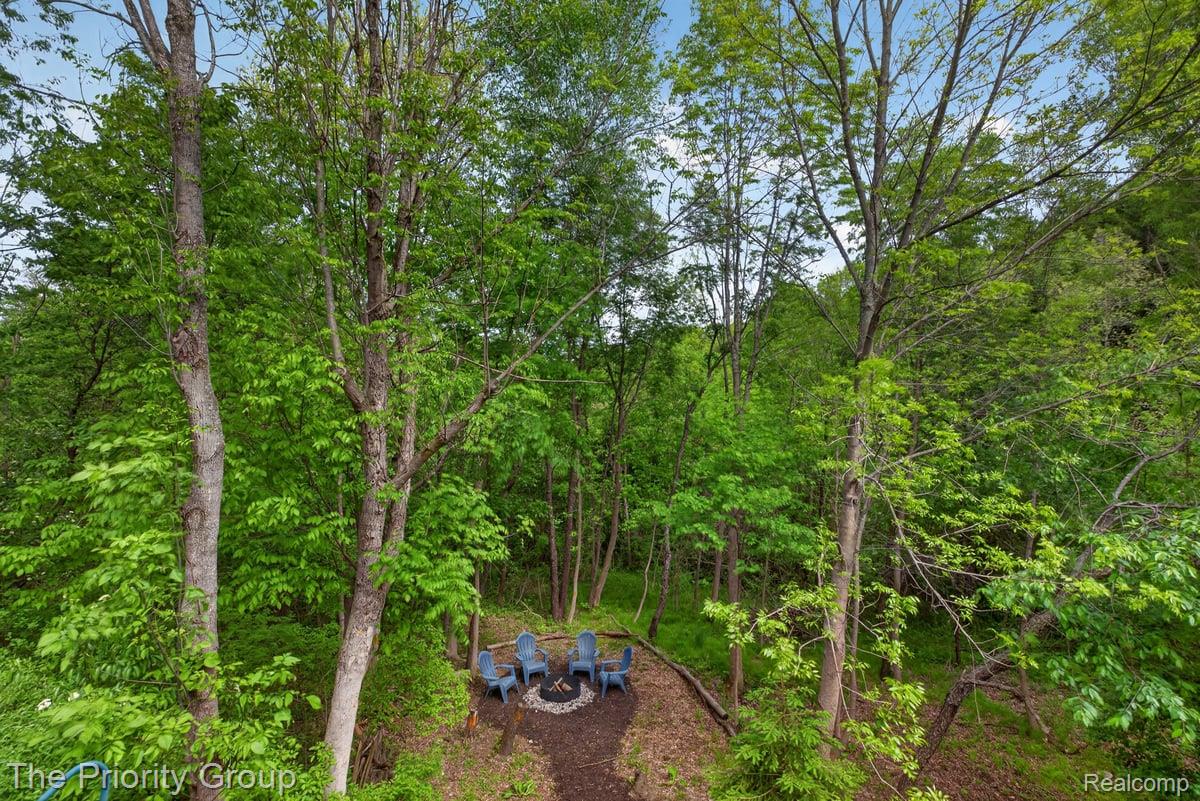 517 Deer Valley Road Holly, MI 48442 - Photo 49 of 61 View from back deck of the yard featuring a view of trees and a fire pit