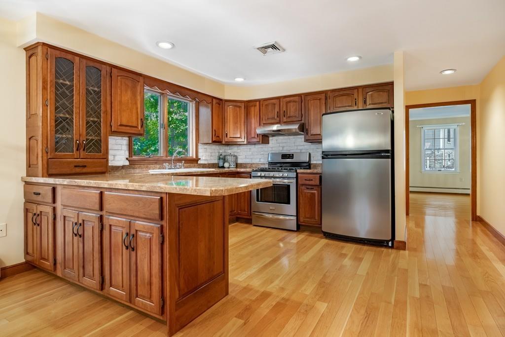 2 Alben Street Winchester, MA 01890 - Photo 11 of 33 a kitchen with stainless steel appliances granite countertop a refrigerator a sink dishwasher a stove with large oven and wooden floor