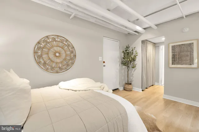 a bedroom with a bed and a painting on the wall