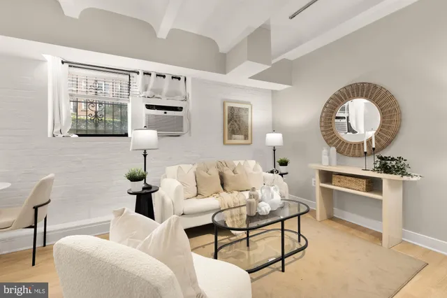 a living room with furniture a flat screen tv and kitchen view