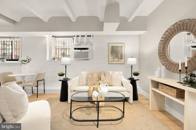 a living room with furniture a flat screen tv and a table