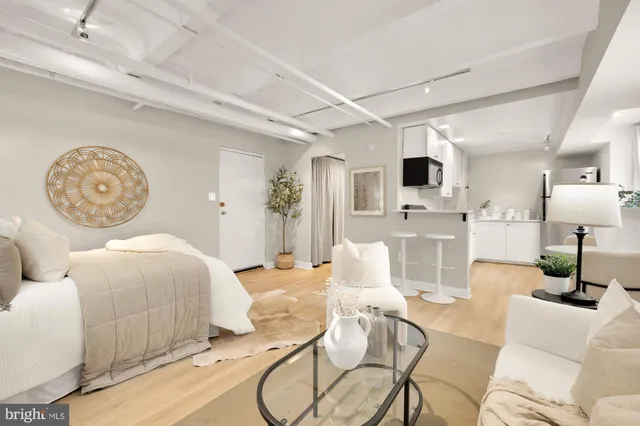 a living room with furniture a flat screen tv and kitchen view