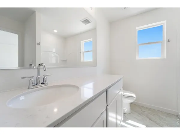 a bathroom with a sink a toilet a mirror and vanity