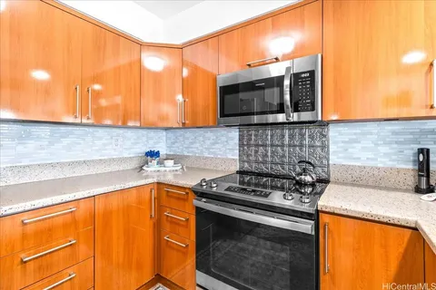 a kitchen with stainless steel appliances granite countertop a stove a sink and a microwave
