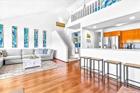 a living room with furniture and a large window with wooden floor