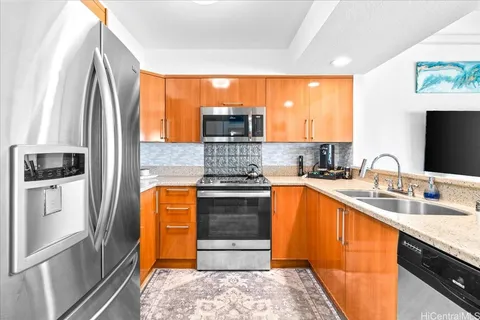 a kitchen with stainless steel appliances granite countertop a stove a sink and a refrigerator