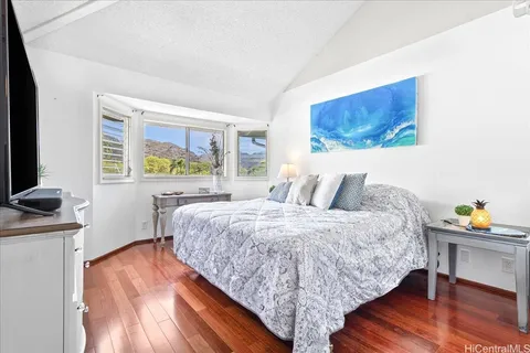 a bedroom with a bed and a dresser next to a window