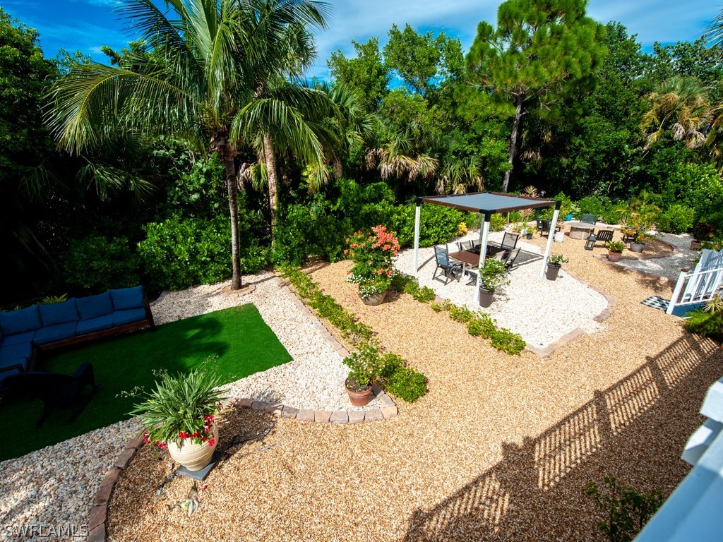 1434 Sand Castle Road Sanibel, FL 33957 - Photo 27 of 35 a view of a backyard with plants and palm tree