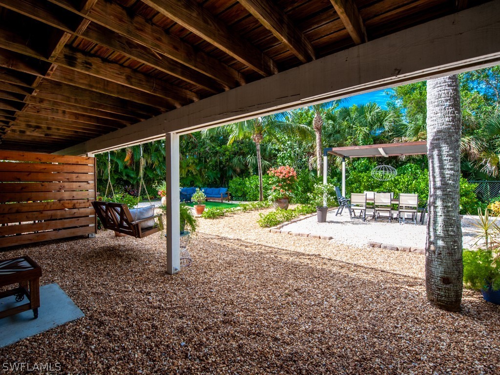 1434 Sand Castle Road Sanibel, FL 33957 - Photo 28 of 35 a view of a patio with a table chairs and a backyard