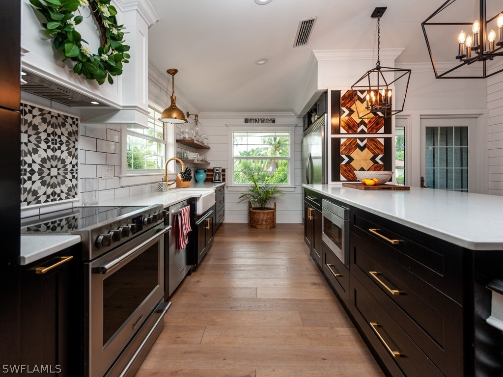 1434 Sand Castle Road Sanibel, FL 33957 - Photo 9 of 35 a large kitchen with stainless steel appliances granite countertop a stove a sink and a refrigerator