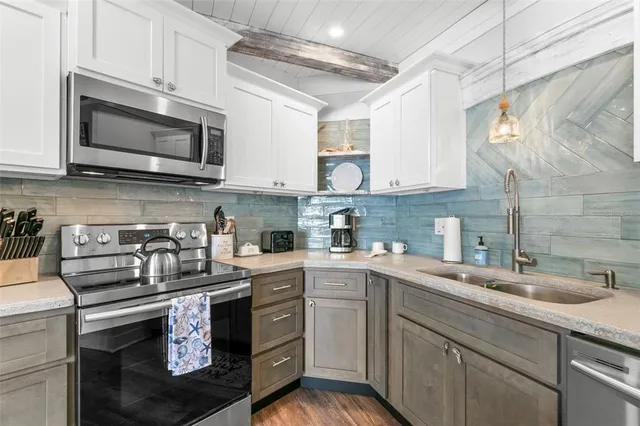 a kitchen with stainless steel appliances a sink a stove and cabinets