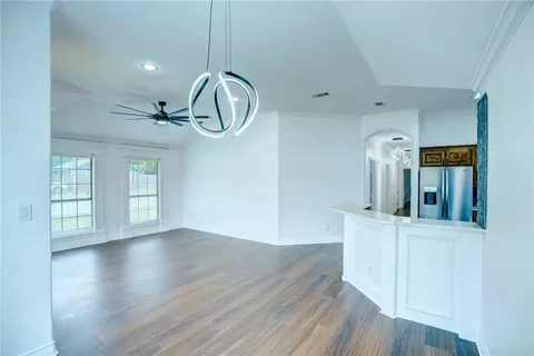 a view of a room with wooden floor staircase and kitchen view