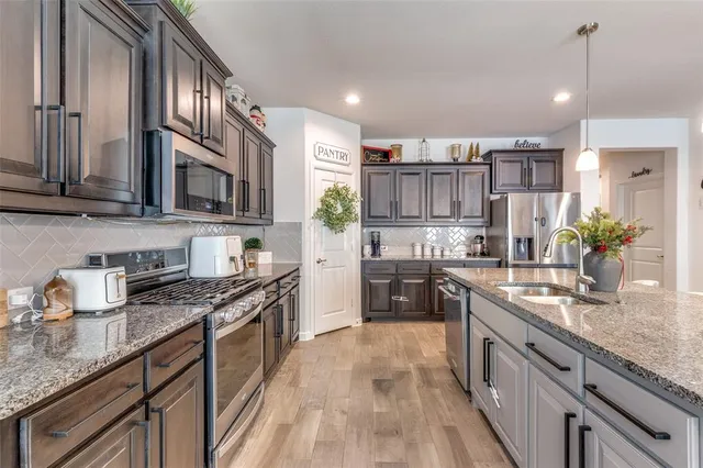 a kitchen with kitchen island granite countertop a sink stove and cabinets