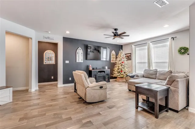 a living room with furniture and a wooden floor