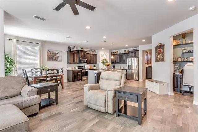 a living room with furniture kitchen view and a window