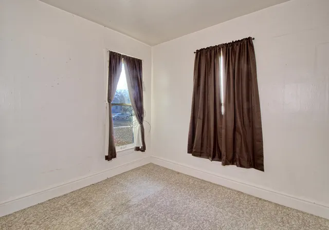 an empty room with a fireplace and a window