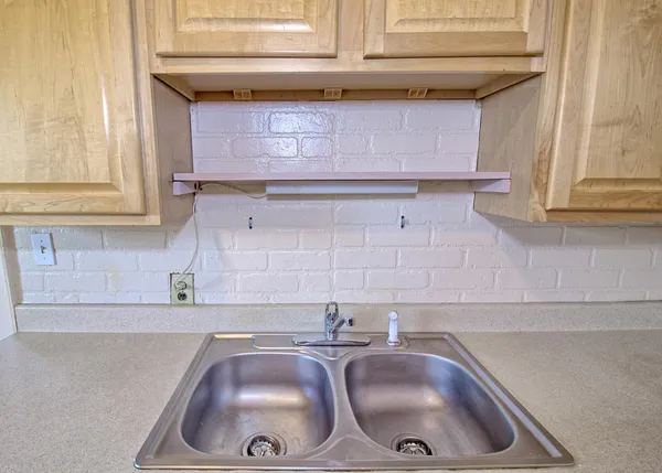 a kitchen with granite countertop a sink and a wooden cabinets