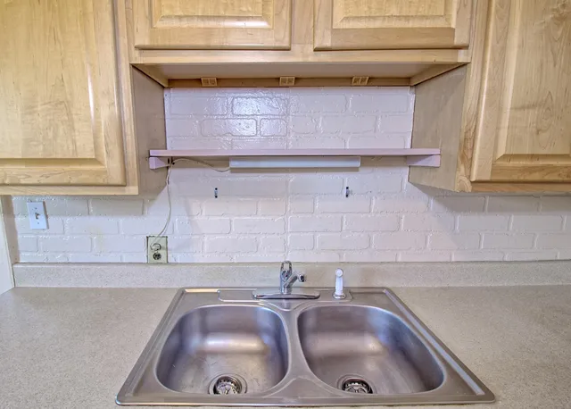 a kitchen with granite countertop a sink and a wooden cabinets
